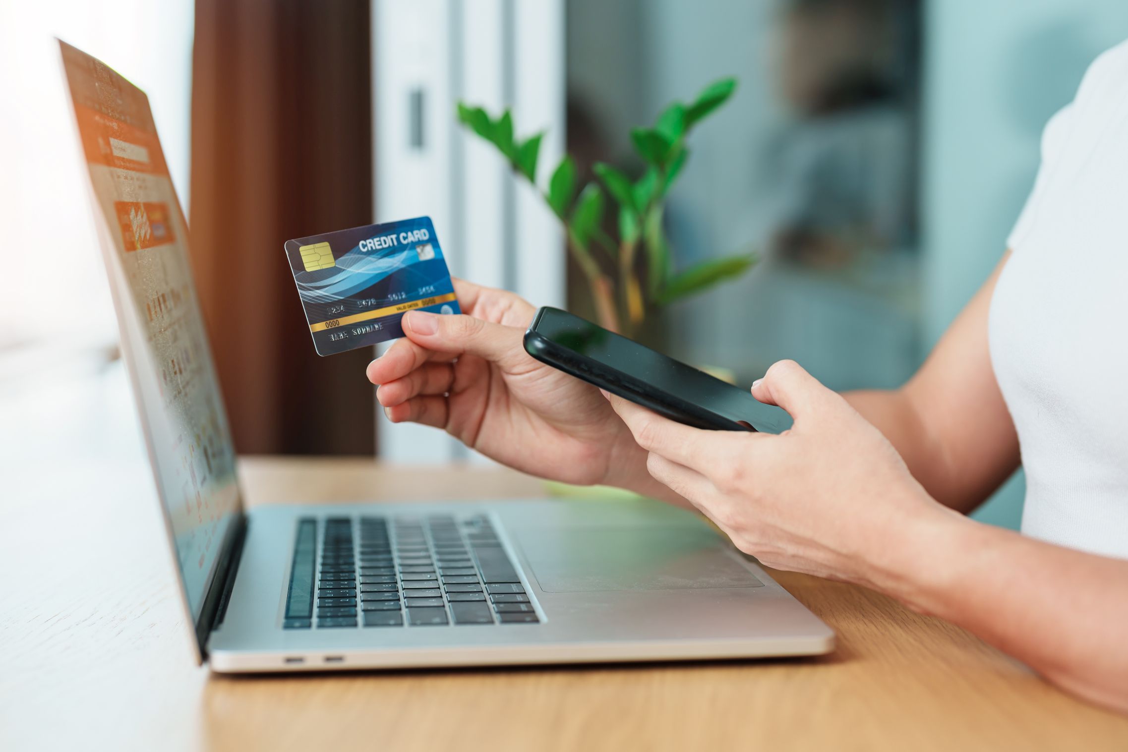 woman hand holding credit card and using laptop with mobile phon